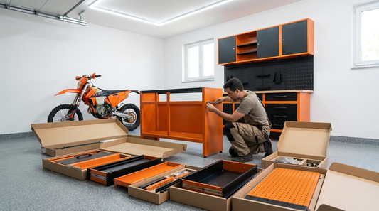 Rider montando un banco de trabajo metálico naranja Metallmobell en su garaje con una moto KTM al fondo
